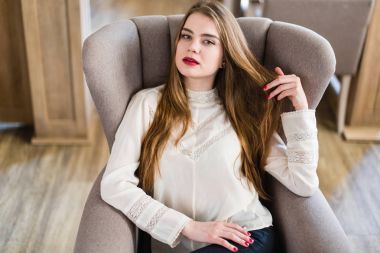 Profesyonel makyaj ve saç modeli restoranda oturan güzel genç kızla.