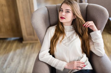 Profesyonel makyaj ve saç modeli restoranda oturan güzel genç kızla.