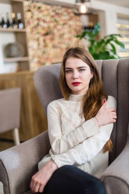 Profesyonel makyaj ve saç modeli restoranda oturan güzel genç kızla.