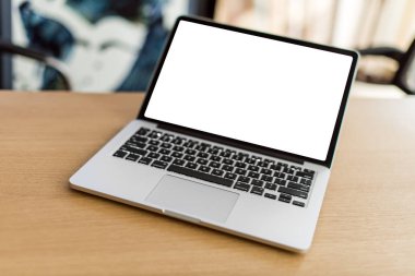 Ahşap masa ve arka plan bulanık boş ekran ile dizüstü bilgisayar