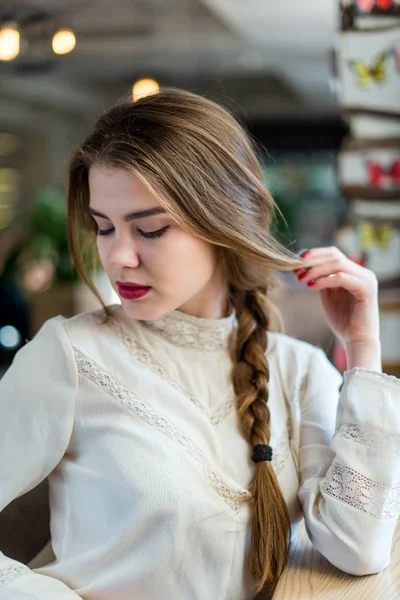 Profesyonel makyaj ve saç modeli restoranda oturan güzel genç kızla.