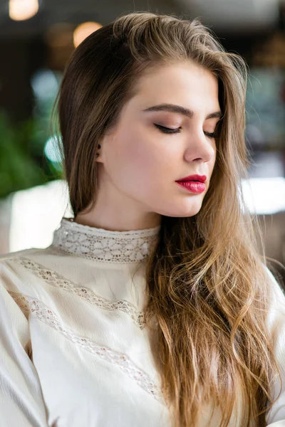 Retrato de una hermosa joven con maquillaje profesional y peinado en el restaurante . — Foto de Stock