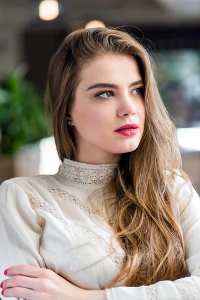 Profesyonel makyaj ve saç modeli restoranda oturan güzel genç kızla.