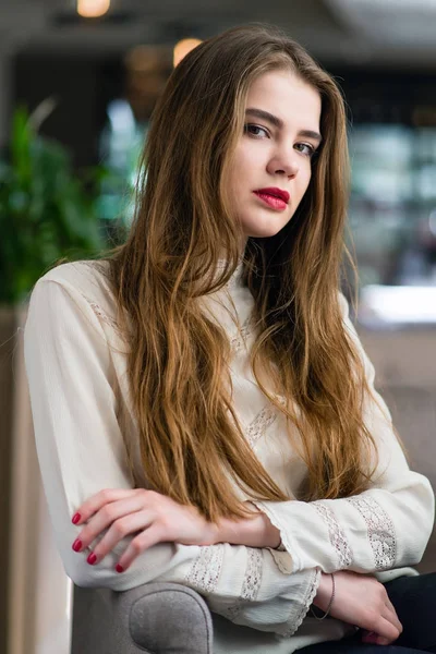 Profesyonel makyaj ve saç modeli restoranda oturan güzel genç kızla.