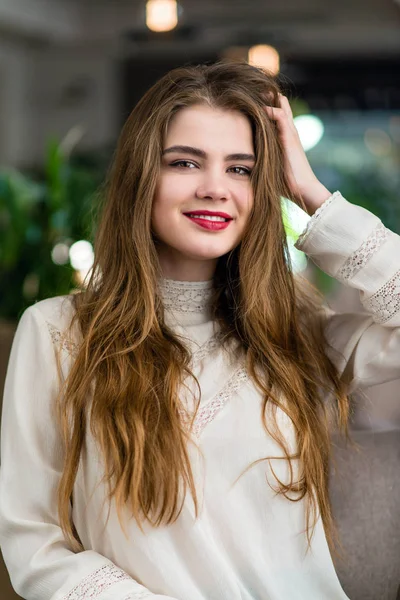 Profesyonel makyaj ve saç modeli restoranda oturan güzel genç kızla.