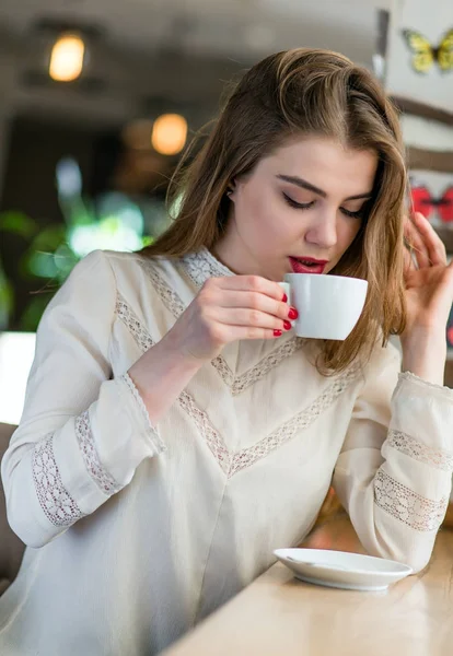 Profesyonel makyaj ve saç modeli restoranda oturan güzel genç kızla.