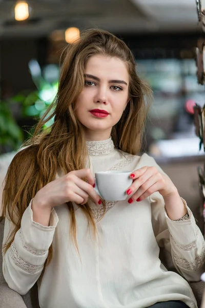 Profesyonel makyaj ve saç modeli restoranda oturan güzel genç kızla.