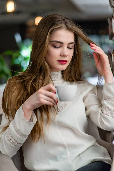 Profesyonel makyaj ve saç modeli restoranda oturan güzel genç kızla.