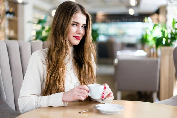 Profesyonel makyaj ve saç modeli restoranda oturan güzel genç kızla.