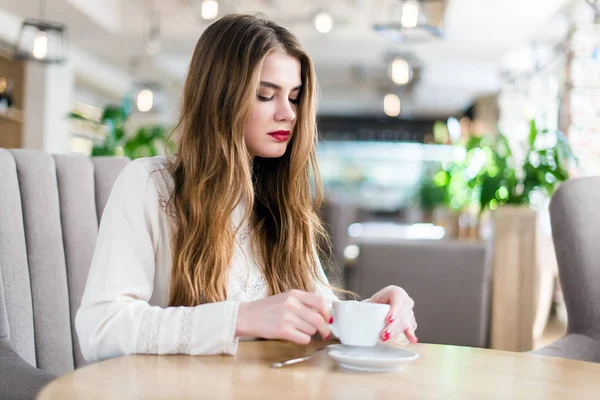 Profesyonel makyaj ve saç modeli restoranda oturan güzel genç kızla.