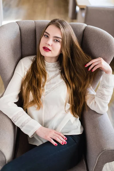 Profesyonel makyaj ve saç modeli restoranda oturan güzel genç kızla.