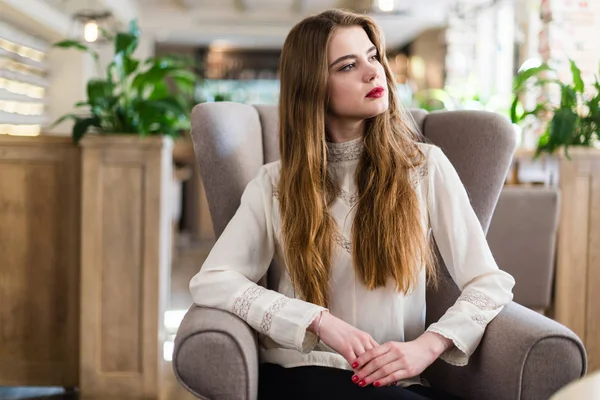 Profesyonel makyaj ve saç modeli restoranda oturan güzel genç kızla.