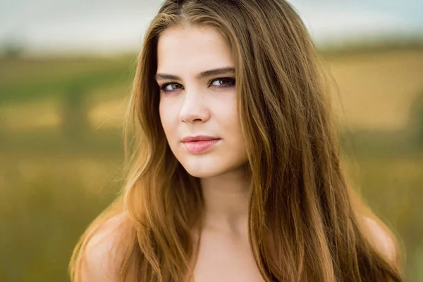 Retrato de una hermosa chica en un campo — Foto de Stock