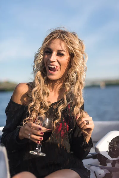 Retrato de mulher atraente relaxante no iate desfrutando de um copo de vinho no céu azul mar ao ar livre. Desfrute e estilo de vida de luxo — Fotografia de Stock