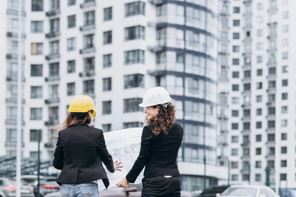 Kask ve koruyucu gözlük düzenleri, konsept binasında arıyorum binada iki iş kadınları