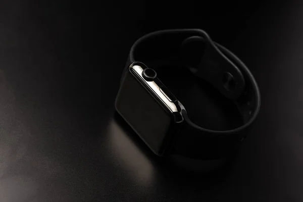 Чорний розумний годинник, розташований на чорному тлі — стокове фото