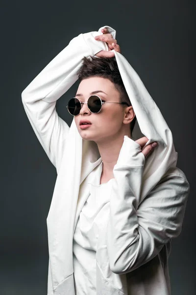 Portret van een mooi jong meisje dragen een witte vacht en zonnebril — Stockfoto