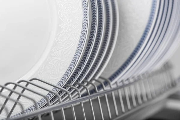 Набір чистих білих тарілок, розташованих у шафі — стокове фото