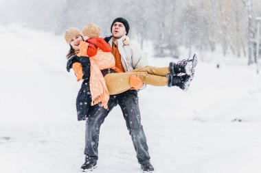 Kışın parkta oynayan sevimli aile