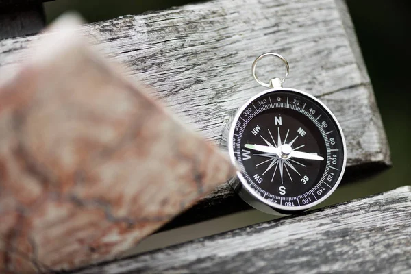 Boussole et carte sur une belle surface en bois. Vue du dessus — Photo