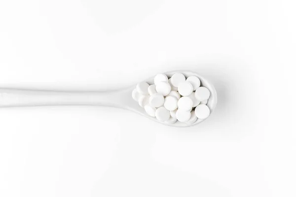 Pil di sendok dan tersebar di permukaan putih — Stok Foto