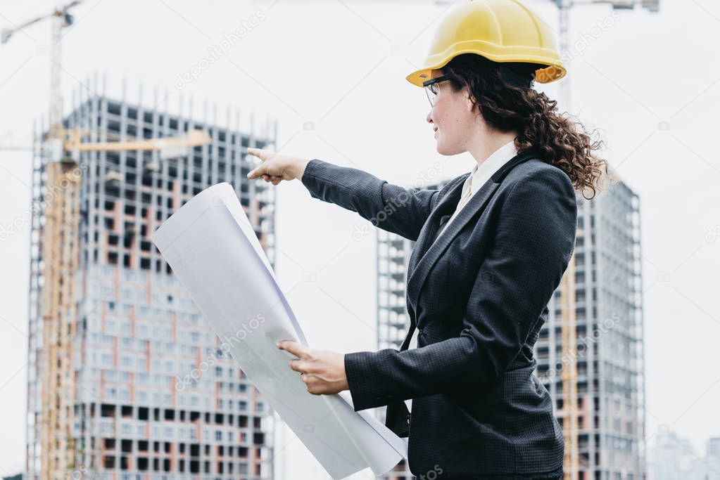 A portrait of engineer woman looking at construction. Woman arch