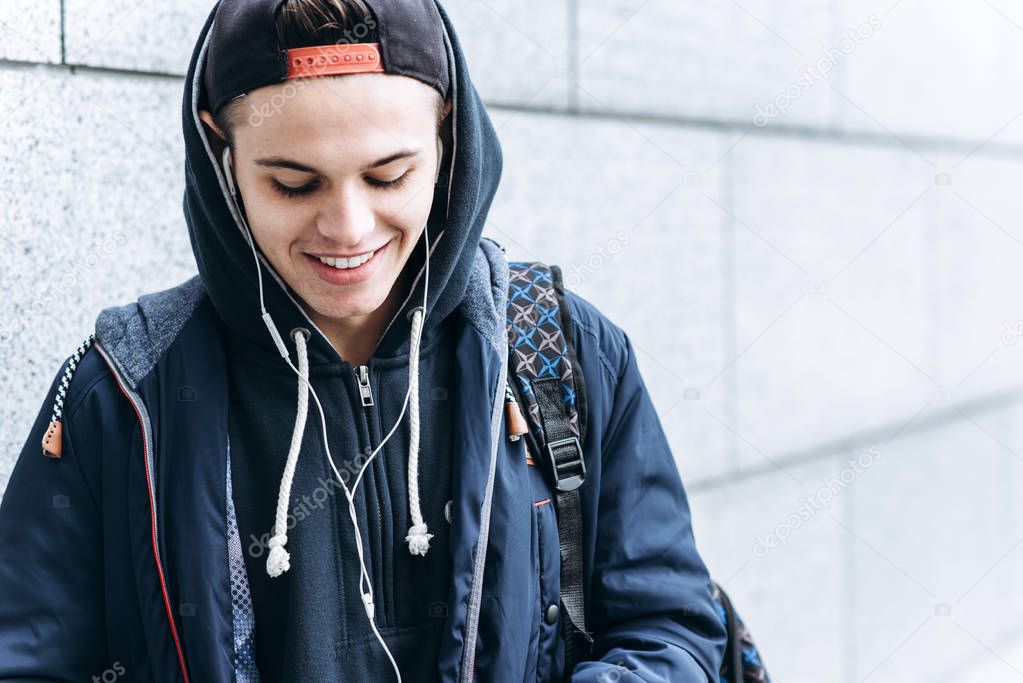 Portrait of cheerful teenager outdoors on blurred background, closeup