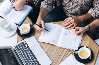 Üstten Görünüm defterini, kitap ve dizüstü bilgisayar ile insan. Kahve Tablo