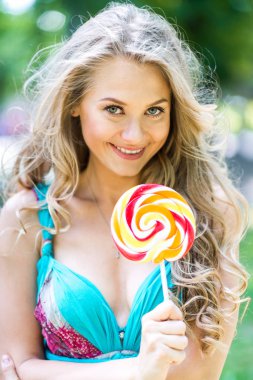 Yaz aylarında parkta bir lolipop ile çekici sarışın kız