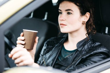 Arabasını süren genç bir kadın.