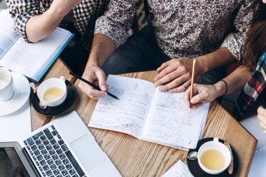 Üstten Görünüm defterini, kitap ve dizüstü bilgisayar ile insan. Kahve Tablo