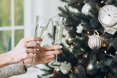 Bir bardak şampanya Noel ağacı çerçevede bir elinde. Noel ve yeni yıl kavramı
