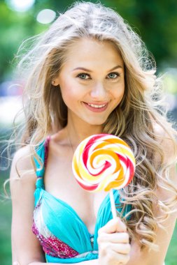 Yaz aylarında parkta bir lolipop ile çekici sarışın kız