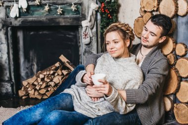 Şömine yakın bir fincan güzel çiftle. Noel ve yeni yıl kavramı