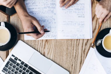 Üstten Görünüm defterini, kitap ve dizüstü bilgisayar ile insan. Kahve Tablo