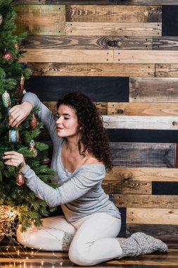 Genç kadın Noel ağacı evde dekorasyon. Noel ve yeni yıl kavramı