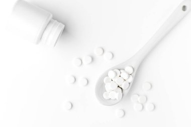 Hapları kaşık ve beyaz yüzeyinde dağınık