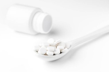 Hapları kaşık ve beyaz yüzeyinde dağınık