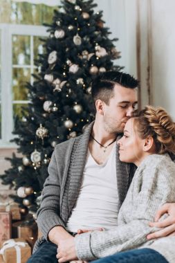 Genç güzel bir şekilde dekore edilmiş Noel odada çift. Noel ve yeni yıl kavramı