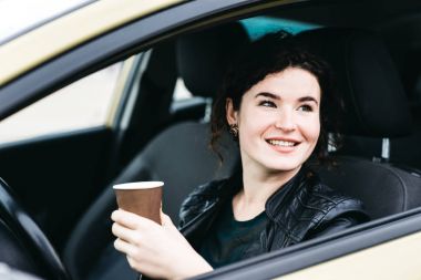 Araba kapalı kadın gülümseyen etrafında dönerek tekerleği tutar