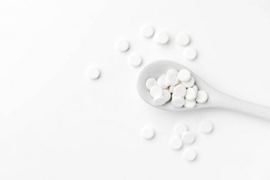 Hapları kaşık ve beyaz yüzeyinde dağınık