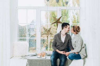 Genç güzel bir Noel dekore edilmiş oda pencere üzerinde çift. Noel ve yeni yıl kavramı