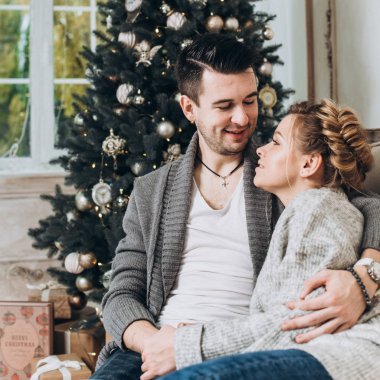 Genç güzel bir şekilde dekore edilmiş Noel odada çift. Noel ve yeni yıl kavramı