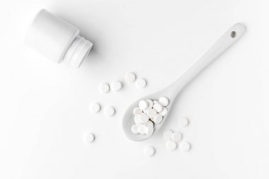 Hapları kaşık ve beyaz yüzeyinde dağınık