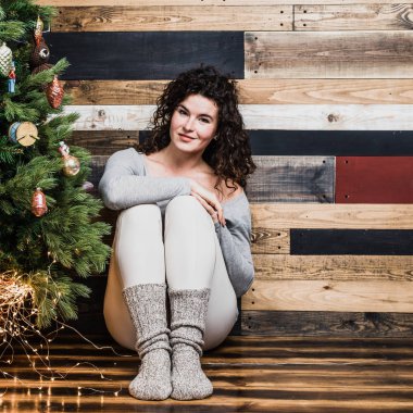 Güzel romantik kız Noel ağacının yanında oturur. Noel ve yeni yıl kavramı