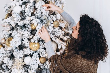 Genç kadın Noel ağacı evde dekorasyon. Noel ve yeni yıl kavramı