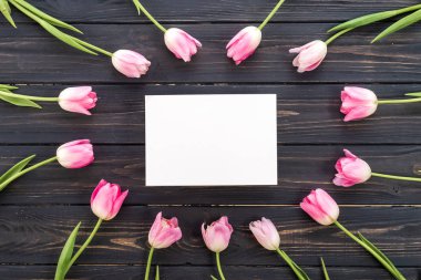 Fresh pink tulip flowers on wooden table. Copy space in the middle