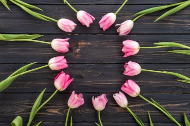 Birthday or wedding mockup with pink tulip flowers on wooden background top view.
