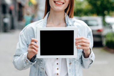 Cropping image a girl holding black mockup screen of ipad in her