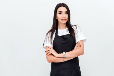 Confident hairstylist folds her arms and looks into the camera